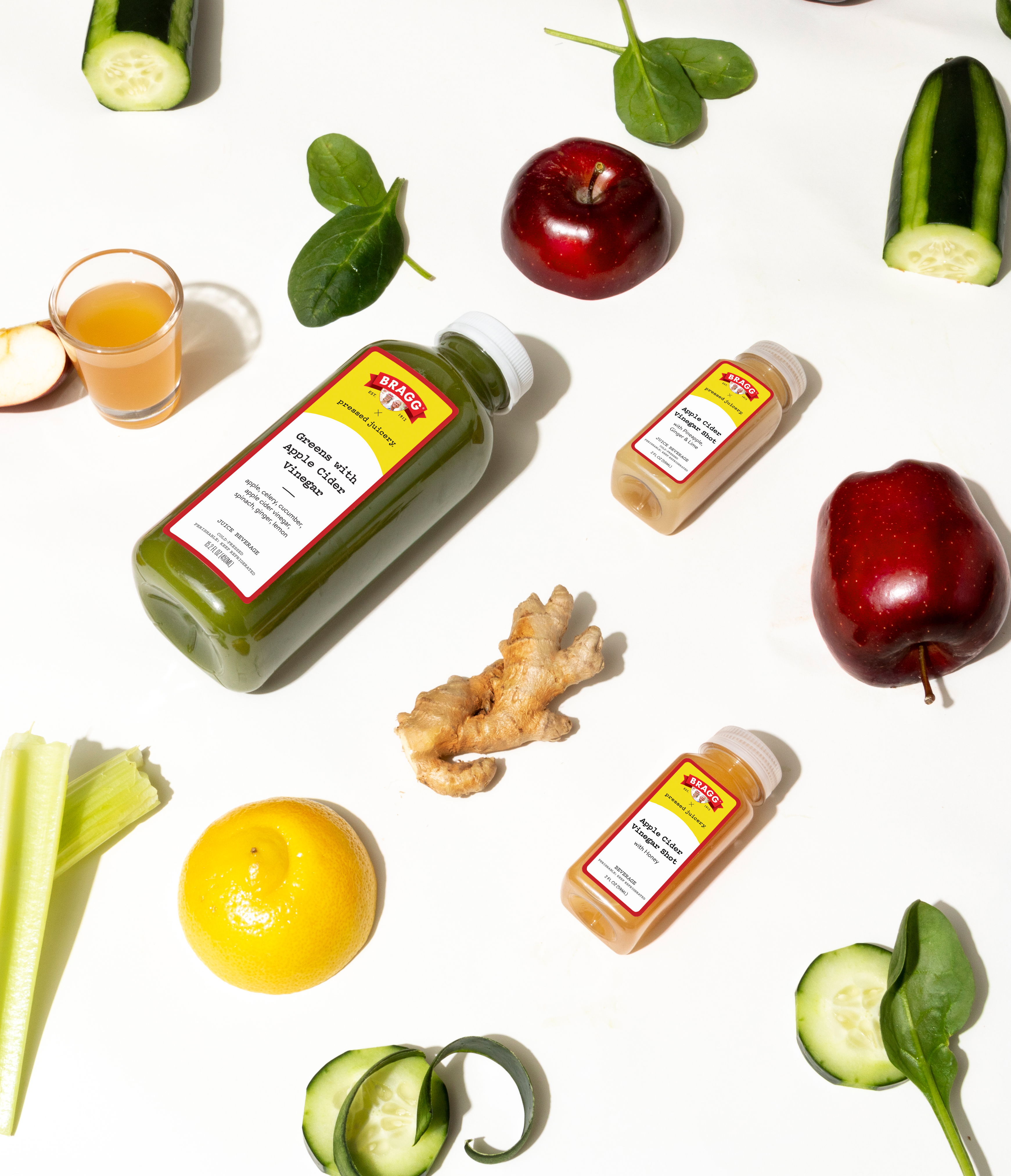Bragg apple cider vinegar juice and shot with sliced fruits and vegetables